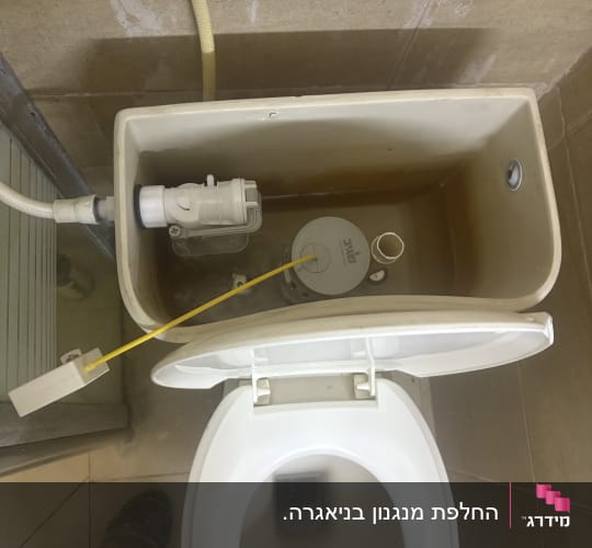 מיכל הדחה פתוח עם צנרת וחלקים פנימיים